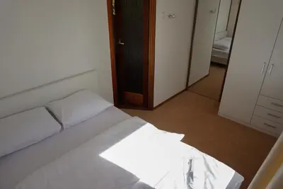 a bedroom with a white bed and a closet at Chalet at a holiday park in Opmeer near Amsterdam in Opmeer