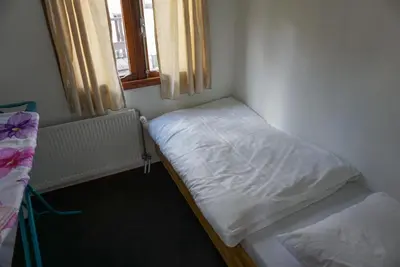 a small room with a bed and a window at Chalet at a holiday park in Opmeer near Amsterdam in Opmeer