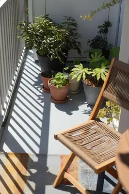 a wooden chair sitting on a balcony with potted plants at Gorgeous And Stylish Place For Two In Hip West! in Amsterdam