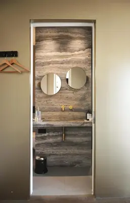 a bathroom with a wooden wall with two mirrors at 'Room Eleven' aan de Vecht in Vreeland