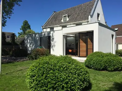 a white house with a black and white roof at 'Room Eleven' aan de Vecht in Vreeland