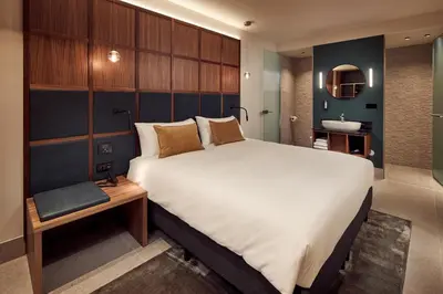 a bedroom with a large bed and a bathroom at Met Hotel Amsterdam in Amsterdam