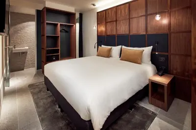 a bedroom with a large bed and a bathroom at Met Hotel Amsterdam in Amsterdam