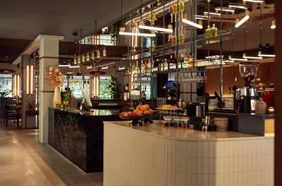 a bar in a restaurant with a bowl of fruit on a counter at Met Hotel Amsterdam in Amsterdam