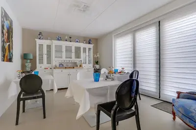 a living room with a table and chairs and a kitchen at B&B Modern Times in Amsterdam