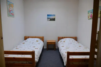 two twin beds in a room with two tables at Bas Apartment Egmond aan Zee in Egmond aan Zee