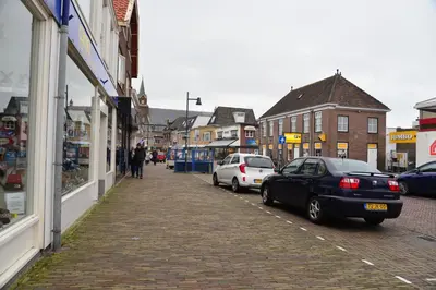 a street with cars parked on the side of a building at Bas Apartment Egmond aan Zee in Egmond aan Zee