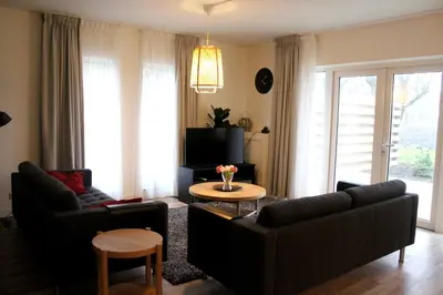a living room with two couches and a table at Polderhoek in Woubrugge