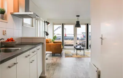 a kitchen with white cabinets and a view of a living room at Bluff in Aalsmeer