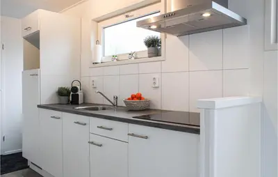 a white kitchen with a sink and a window at Bluff in Aalsmeer