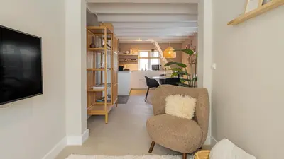 a living room with a chair and a television at Casa de la Pelt in Bergen