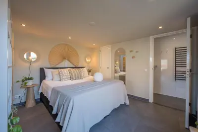 a bedroom with a large bed and a bathroom at De Grote Stern in Groet