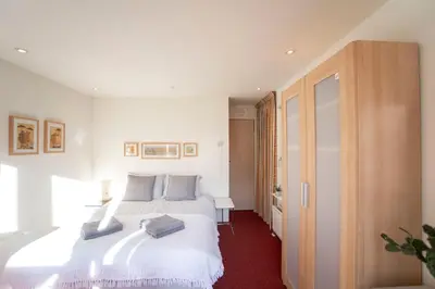 a bedroom with a large white bed in a room at Studio 19 with private parking in Zandvoort