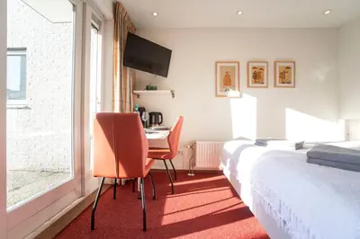 a bedroom with a bed and a table and chairs at Studio 19 with private parking in Zandvoort
