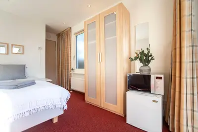 a bedroom with a bed and a tv on a cabinet at Studio 19 with private parking in Zandvoort