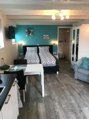 a bedroom with a bed and a table in a room at Mikasabeach in Zandvoort