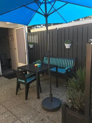 a blue umbrella sitting next to a table and a bench at Mikasabeach in Zandvoort