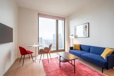 a living room with a blue couch and a table at PREMIER SUITES Amsterdam in Amsterdam