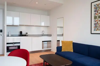 a living room with a blue couch and a table at PREMIER SUITES Amsterdam in Amsterdam