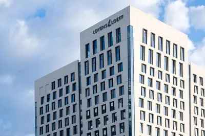 a tall white building with a sign on it at PREMIER SUITES Amsterdam in Amsterdam