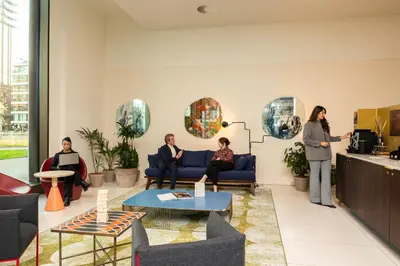 a group of people sitting in a lobby with a presentation at PREMIER SUITES Amsterdam in Amsterdam