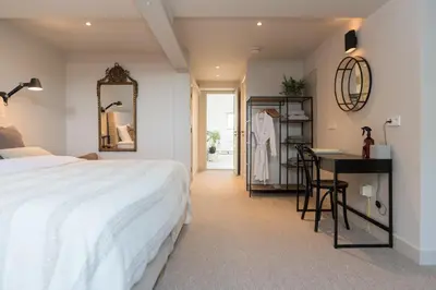 a bedroom with a bed and a desk and a mirror at Empire suites roof terras in Amsterdam