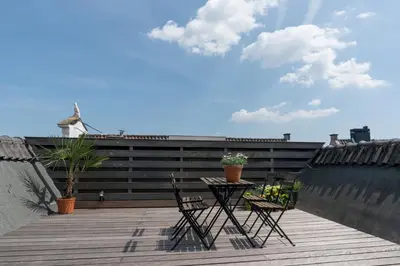 a patio with a table and chairs on a balcony at Empire suites roof terras in Amsterdam