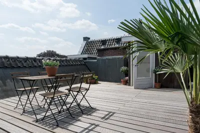 a patio with a table and chairs on a deck at Empire suites roof terras in Amsterdam