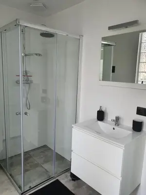 a white bathroom with a shower and a sink at Studio Adanni in Zandvoort