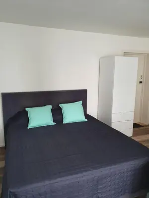 a bedroom with a bed with two blue pillows at Studio Adanni in Zandvoort