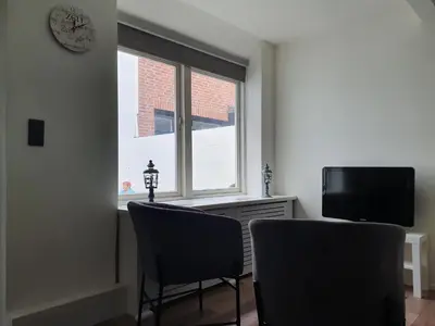 a living room with two chairs and a window at Studio Adanni in Zandvoort
