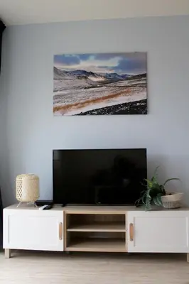 a flat screen tv sitting on top of a white entertainment center at Landzicht in Woubrugge