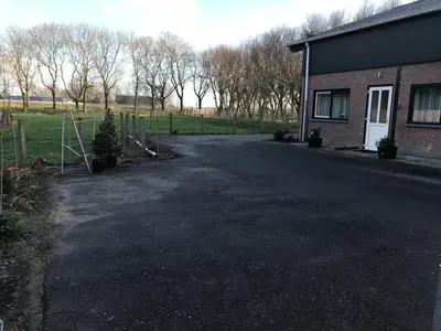 an empty driveway in front of a house at Landzicht in Woubrugge
