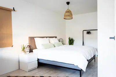 a bedroom with a bed and a pendant light at Studio Puuur in Zandvoort