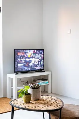 a living room with a tv and a coffee table at Studio Puuur in Zandvoort