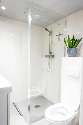 a white bathroom with a toilet and a shower at Studio Puuur in Zandvoort