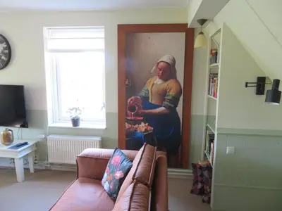 a living room with a painting of a man eating food at Holiday apartment with free parking Boven Jan Enkhuizen in Enkhuizen