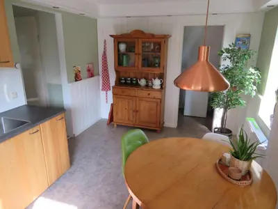 a kitchen with a wooden table and a dining room at Holiday apartment with free parking Boven Jan Enkhuizen in Enkhuizen