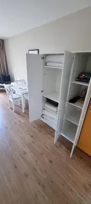 an empty white cabinet with two white chairs in a room at Casa de Deborah in Zandvoort