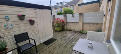 a patio with a chair and a table and a fence at Casa de Deborah in Zandvoort