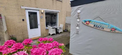 a surfboard on the side of a house with flowers at Casa de Deborah in Zandvoort