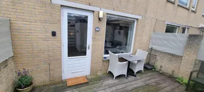 a patio with a table and chairs next to a building at Casa de Deborah in Zandvoort