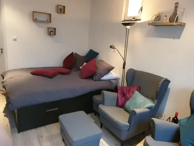 a bed and a chair in a room at Sunset Lodge in Zandvoort