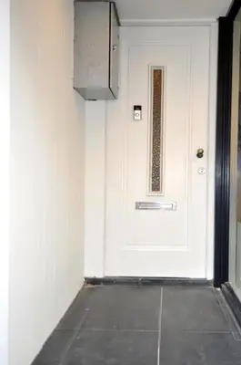 a white door in a room with a tile floor at Zaras Studios in Zandvoort