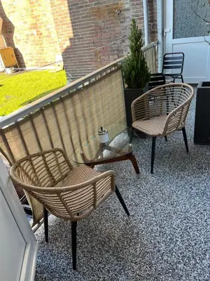two wicker chairs sitting on a balcony at Zaras Studios in Zandvoort