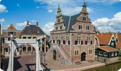 a large brick building with a tower on top of it at Huisje Finn, met grote tuin en veel privacy in Dirkshorn