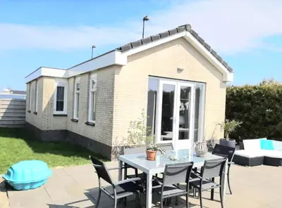 a patio with a table and chairs in front of a house at Huisje Finn, met grote tuin en veel privacy in Dirkshorn