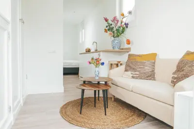 a living room with a couch and a table at Tiny Beach House Zandvoort in Zandvoort