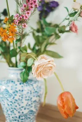 a blue and white vase with flowers in it at Tiny Beach House Zandvoort in Zandvoort