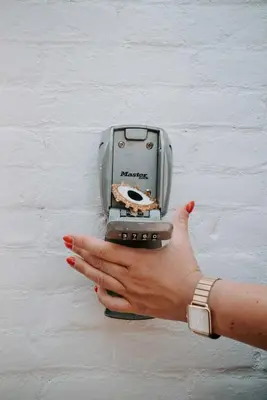 a woman holding a cell phone in front of a wall at Tiny Beach House Zandvoort in Zandvoort